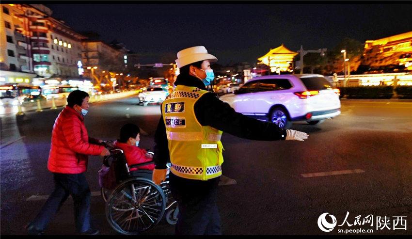 西安交警蓮湖大隊民警引導(dǎo)群眾過馬路。