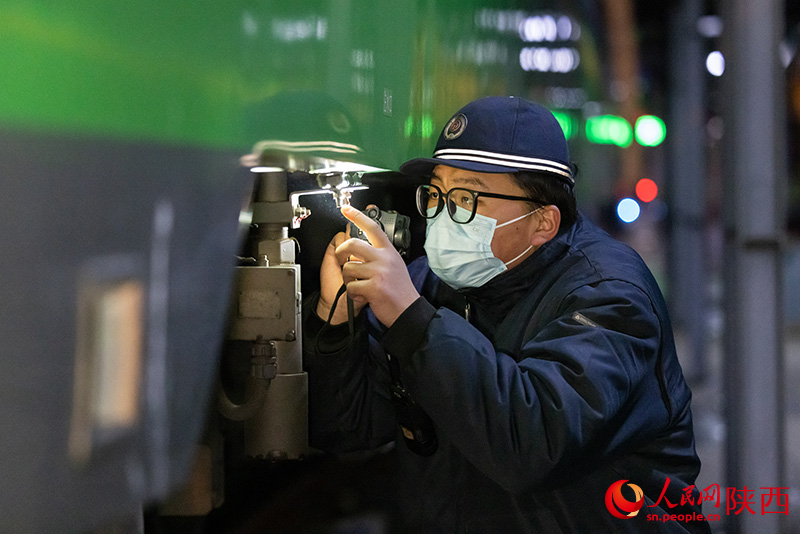 1月26日，西安客車車輛段，鐵路檢修“小哥”正在檢查動(dòng)力集中型動(dòng)車組注水口保證旅客正常用水。劉翔攝