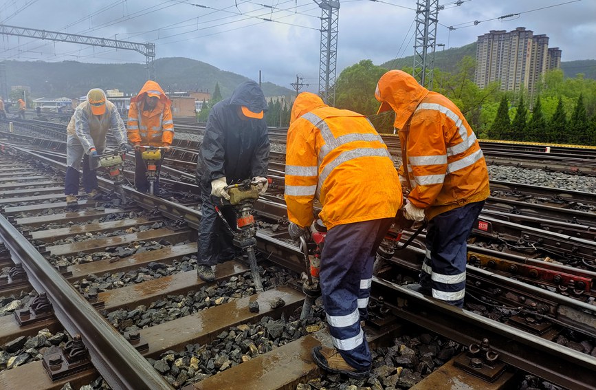 延安工務(wù)段職工雨中對線路幾何尺寸不良處所進行整治。劉一帆攝