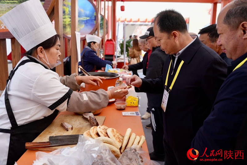 參展觀眾在渭南展館品嘗特色美食。人民網(wǎng)記者 鄒星攝