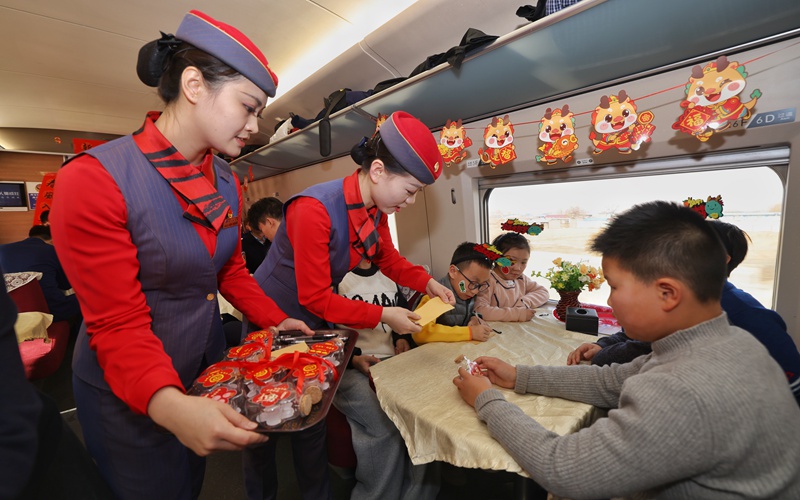 列車工作人員為小旅客們介紹“新春傳福漂流瓶”活動(dòng)。劉松霖 攝