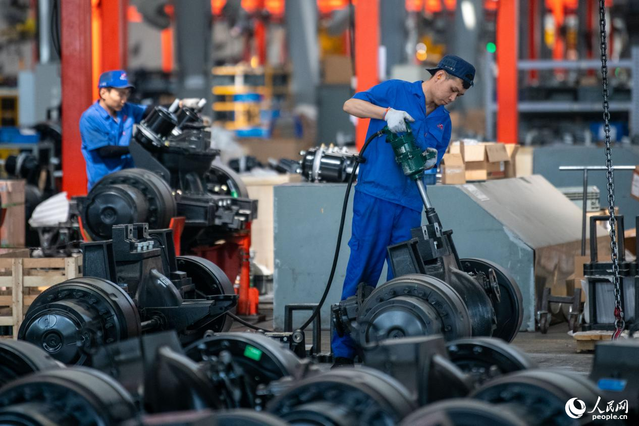 5月14日，在總裝車間，工人正在進行非公路寬體自卸車底盤裝配作業(yè)。人民網(wǎng)記者 翁奇羽攝