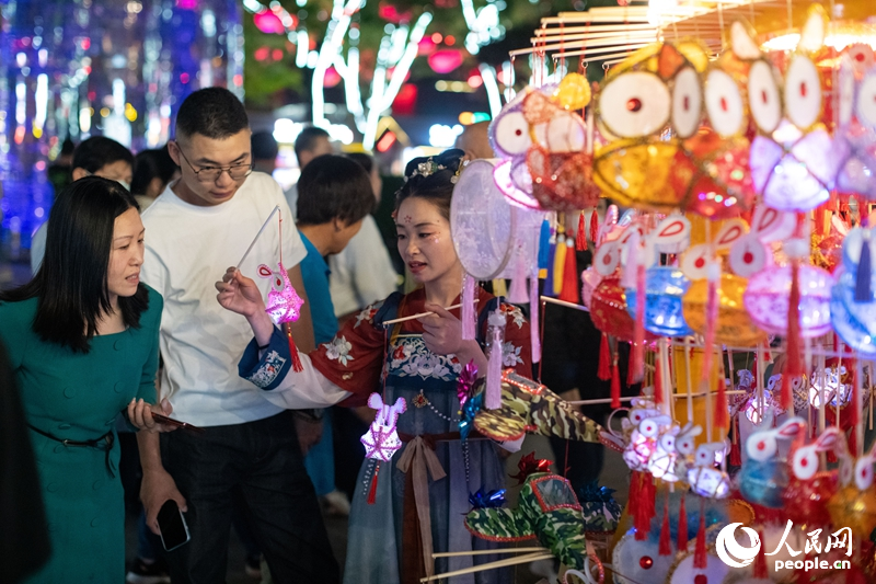 在西安大唐不夜城步行街，游客正在選購手工藝品。人民網(wǎng)記者 翁奇羽攝