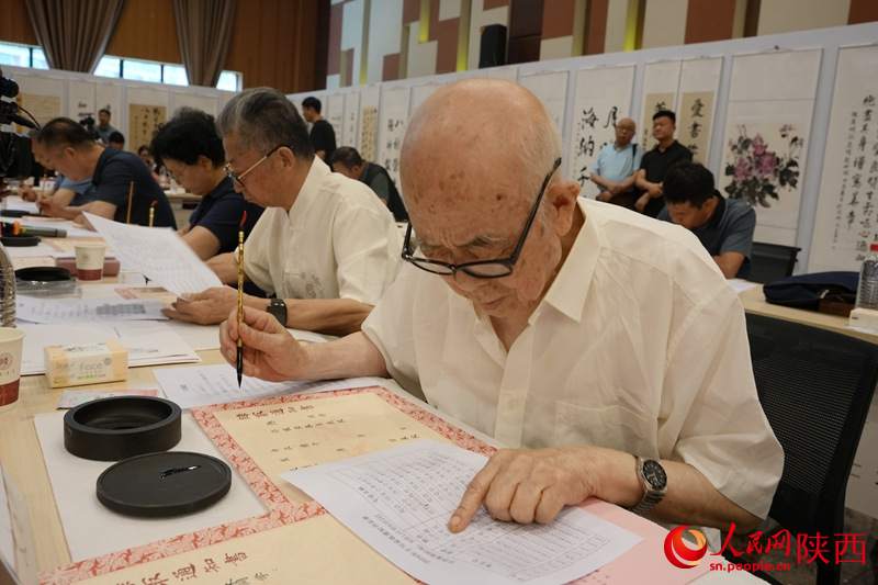 退休教師用毛筆為今年新生手寫錄取通知書。人民網(wǎng)記者 賈凱璐攝